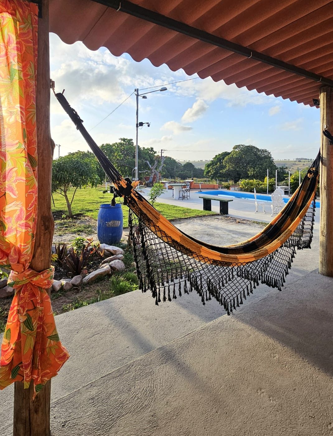 Rede armada na varanda coberta com vista para a piscina do Chalés da Ribeira